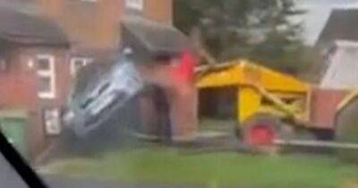 Moment JCB digger ploughs into home and lifts car into air - www.dailyrecord.co.uk - Scotland