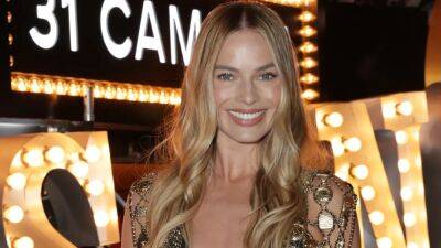 Margot Robbie Wore a Slinky Gold Chain Vest Over a Black Bikini Top at the Chanel Show - www.glamour.com